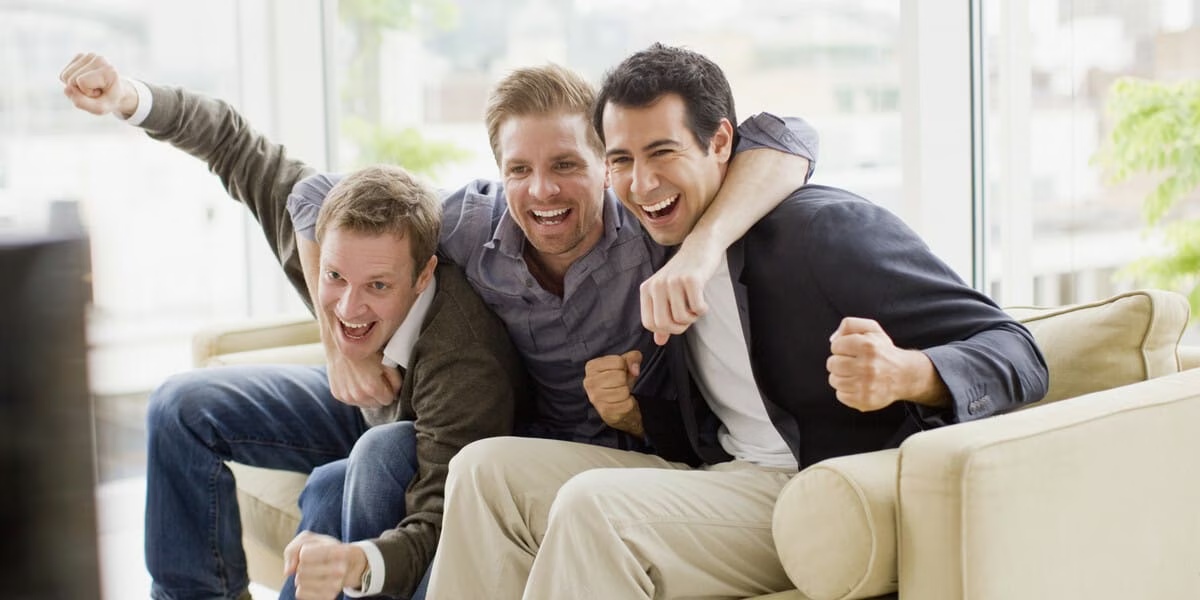 Cheering friends watching television